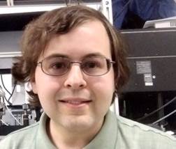 A person wearing glasses and a green shirt

Description automatically generated