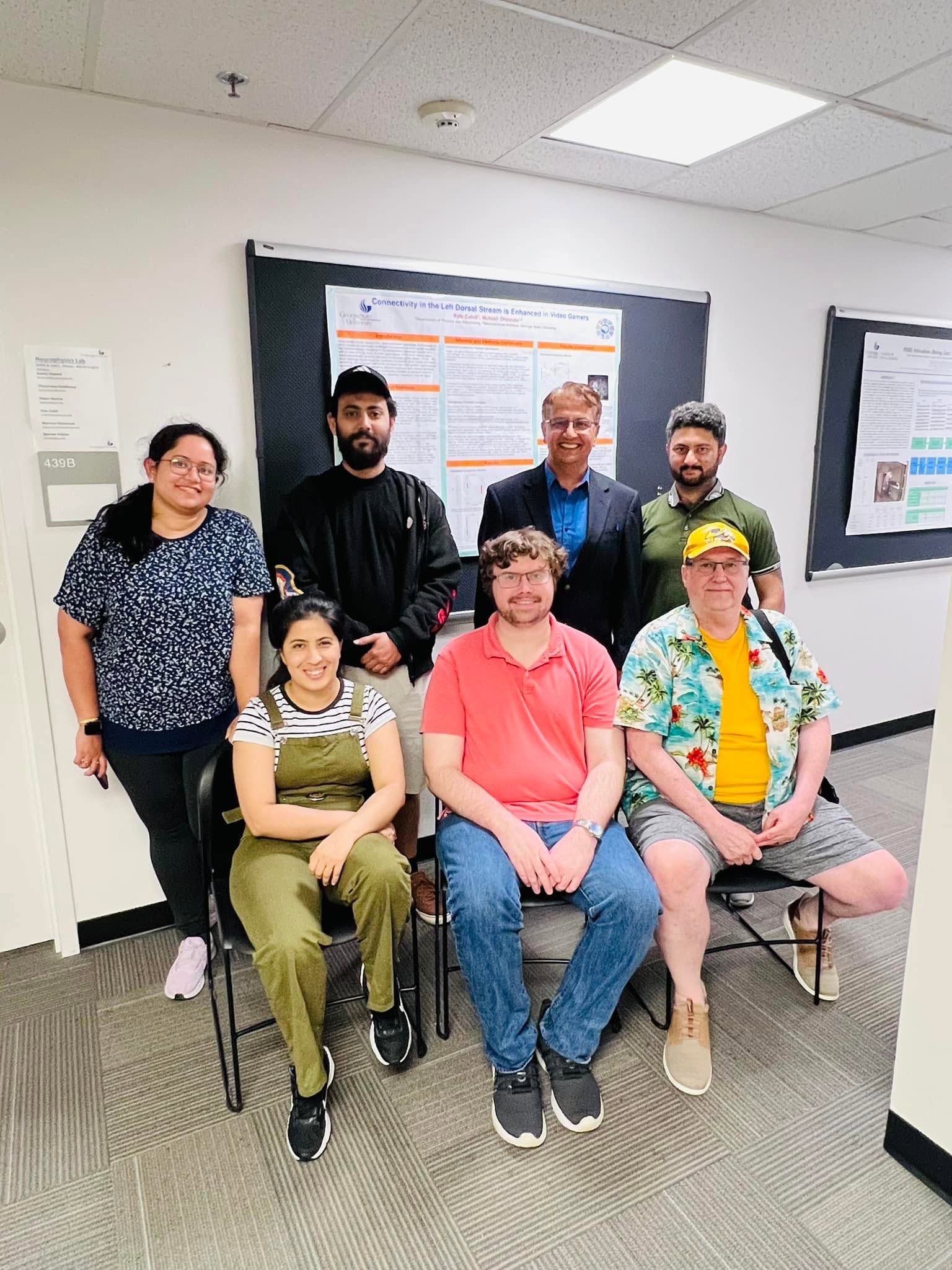 Dhamala Lab group photo in front of research posters